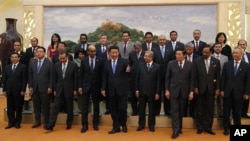 Chinese President Xi Jinping, center, shows the way to guests who attended the signing ceremony of the Asian Infrastructure Investment Bank at the Great Hall of the People in Beijing, Oct. 24, 2014. (AP Photo/Takaki Yajima, Pool)