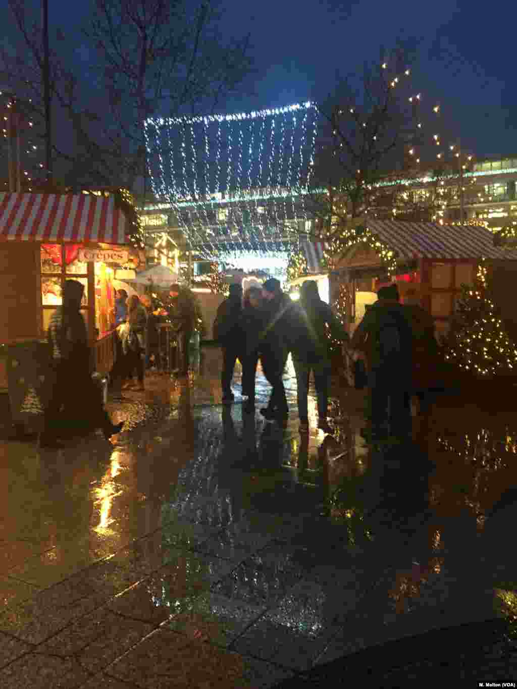 Udara dingin dan gerimis tidak menghalangi para pengunjung untuk menikmati kilauan cahaya lampu, minuman anggur dan barang-barang hadiah liburan berwarna-warni di pasar Natal Berlin, 27 November 2017.