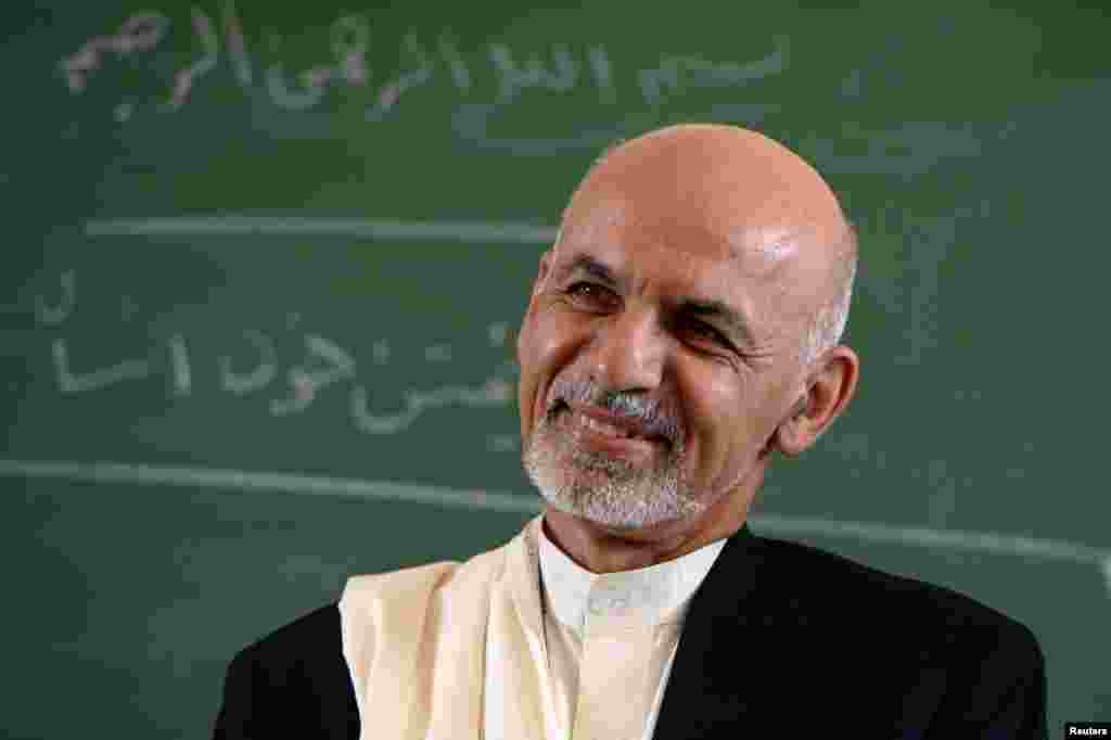 Afghan President Ashraf Ghani listens to students during his visit to the Amani High School in Kabul Sept. 30, 2014.