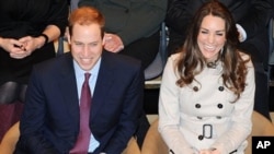 Britain's Prince William and his fiance Kate Middleton applaud as they watch a play at the Youth Action Centre in Belfast, Northern Ireland, Tuesday March 8, 2011.