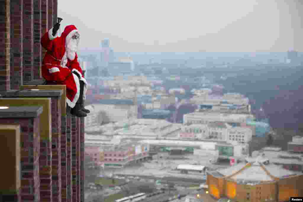 A man dressed as Santa Claus sits at the front of the Kollhoff Tower at Potsdamer Platz square in Berlin, Germany.