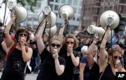 Women hold up megaphones during a protest against the G-20 summit in Hamburg, Germany, July 8, 2017.