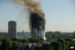 FILE - In this June 14, 2017 file photo, smoke rises from a 24-story high-rise apartment building on fire in London.