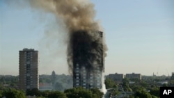 In this June 14, 2017 file photo, smoke rises from a 24-story high-rise apartment building on fire in London.