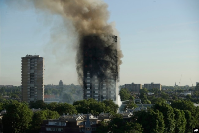 FILE - In this June 14, 2017 file photo, smoke rises from a 24-story high-rise apartment building on fire in London.