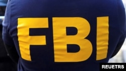 An FBI logo is pictured on an agent's shirt during the U.S. law enforcements raid on Russian oligarch Oleg Deripaska's property in the Manhattan borough of New York City, New York, U.S. October 19, 2021. REUTERS/Carlo Allegri/File Photo