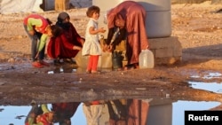  Syrian refugees collect water at Al Zaatri refugee camp near the border with Syria, in the Jordanian city of Mafraq, Sept, 26, 2013.