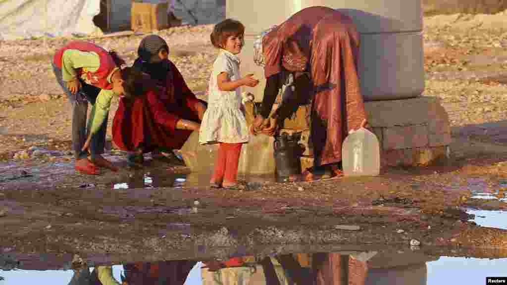 Syrian refugees collect water at Al Zaatri refugee camp near the border with Syria, in the Jordanian city of Mafraq.