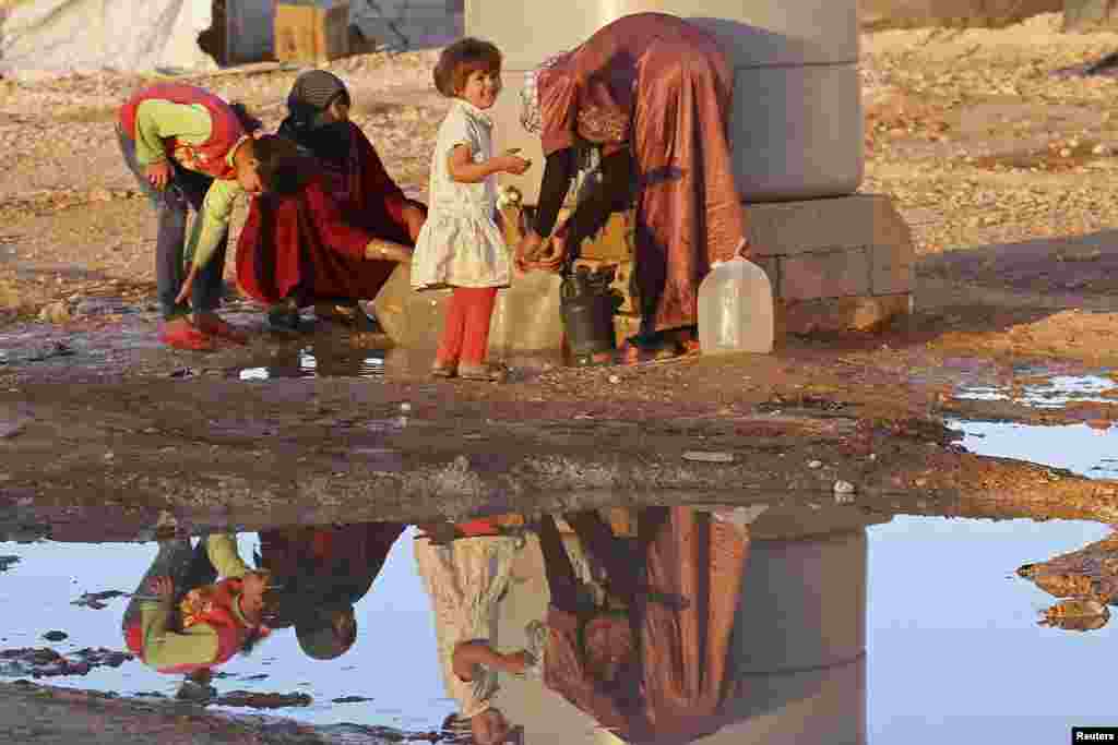 Syrian refugees collect water at Al Zaatri refugee camp near the border with Syria, in the Jordanian city of Mafraq, Sept, 26, 2013.
