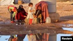 2013年9月26日在约旦境内一个叙利亚难民营取水的照片。