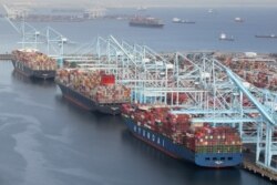 Kontainer pengiriman diturunkan dari kapal di terminal peti kemas di kompleks Pelabuhan Long Beach-Pelabuhan Los Angeles, di tengah pandemi COVID-19, di Los Angeles, California, AS, 7 April 2021. (REUTERS / Lucy Nicholson)