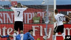 Serbia goalkeeper Vladimir Stojkovic, center, saves a peanlty kick by Germany's Lukas Podolski, right, during the World Cup group D soccer match between Germany and Serbia at Nelson Mandela Bay Stadium in Port Elizabeth, South Africa, 18 Jun 2010