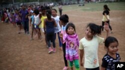 Anak-anak mengantre untuk menerima hadiah di sebuah klub olahraga tempat para migran Amerika Latin melakukan perjalanan tahunan dengan karavan Stations of the Cross di Matias Romero, Meksiko, 4 April 2018. 