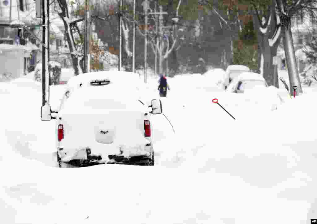 Des véhicules couverts d&rsquo;épaisse couche de neige dans une rue de la région sud Buffalo, jeudi 20 novembre 2014, à Buffalo, NY.