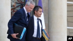 French Finance Minister Bruno Le Maire, left, and French Budget Minister Gerald Darmanin leave the Cabinet meeting at the Elysee Palace in Paris, France, Aug. 23, 2018. 