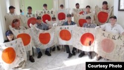 At a Tokyo hotel, the delegation of U.S. World War II vets and family members show off some of the captured war flags they would return on August 4. (Courtesy - Obon 2015)