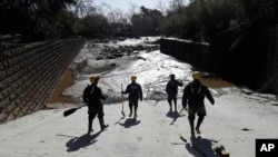 Members of the Los Angeles County Fire Department Search and Rescue crew walk toward flooded waters in Montecito, Calif., Jan. 10, 2018. 