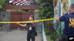 Police mark the crime scene with a yellow tape where two Chinese diplomats were killed in Cebu province, central Philippines on Wednesday Oct. 21, 2015.