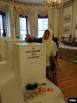 WNI memasukkan surat suara ke kotak dalam pemilu serentak di KJRI New York, Sabtu 13/4 (VOA/Naratama).