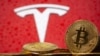 Representasi mata uang virtual Bitcoin di depan logo Tesla, 9 Februari 2021. (Foto: ilustrasi/REUTERS / Dado Ruvic)
