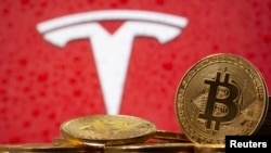 Representasi mata uang virtual Bitcoin di depan logo Tesla, 9 Februari 2021. (Foto: ilustrasi/REUTERS / Dado Ruvic)
