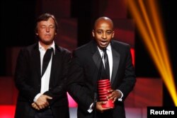 Co-founder of ushahidi.com, David Kobia (R), accepts a Special Achievement award during the 15th annual Webby Awards in New York, June 13, 2011.