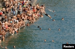People swim during hot summer weather in the Limmat river in Zurich, Switzerland July 1, 2018.