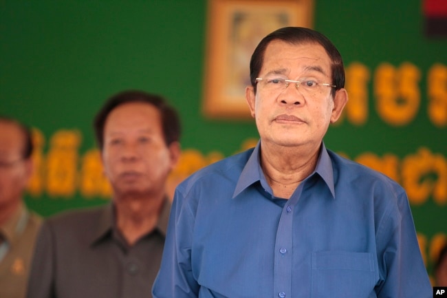 Cambodia's Prime Minister Hun Sen, right, prepares to deliver a speech during a factory visit outside of Phnom Penh, Cambodia, Aug. 30, 2017.
