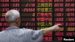 An investor looks at information displayed on an electronic screen at a brokerage house in Shanghai, China, June 30, 2015. 