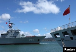 China’s replenishment ship, Qiandaohu, left, sails past its hospital ship, Peace Ark, as it docks in Honolulu, Hawaii.