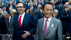 FILE - U.S. Treasury Secretary Steve Mnuchin, left, and Japan's Finance Minister Taro Aso attend the International Monetary Fund (IMF) Governors group photo at World Bank/IMF Spring Meetings, in Washington, April 21, 2018.