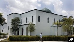 A pedestrian walks past the Jamat Al-Mummineen Mosque in Margate, Florida, where imam Izhar Khan has been charged with providing financial support to the Pakistani Taliban, May 14, 2011