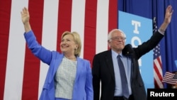 Democratic presidential candidate Hillary Clinton and Sen. Bernie Sanders stand together during a July 12 campaign rally in Portsmouth, N.H.