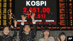 Employees of the Korea Exchange applaud in front of the final stock price index for the ceremonial closing of the 2010 stock market at the Korea Exchange, Seoul, 30 Dec 2010