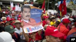Un partidario del presidente venezolano, Nicolás Maduro, muestra su imagen durante un mitin en Caracas, Venezuela, el lunes 13 de agosto de 2018. 