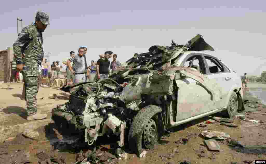 A policeman stands guard at the site of a bomb attack in Kirkuk, north of Baghdad, Iraq, July 23, 2012. 