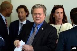FILE - Stephen Bannon waits for President Donald Trump to make a statement about the U.S. role in the Paris climate change accord, June 1, 2017, in the Rose Garden of the White House.