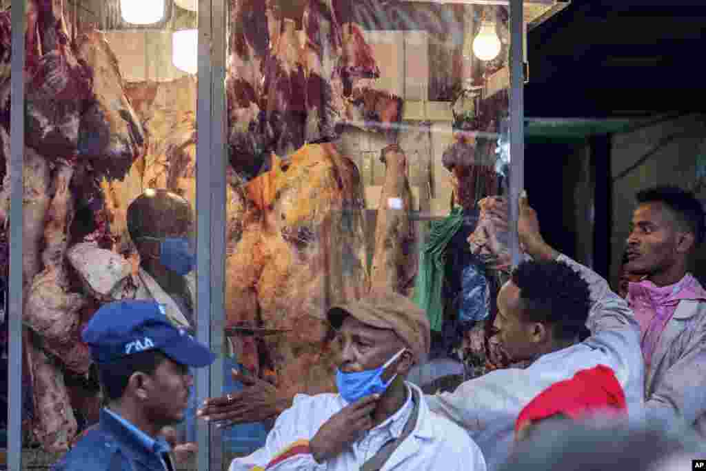 Los carniceros usan máscaras para frenar la propagación del nuevo coronavirus, mientras venden carne de cordero, res y cabra para la Pascua ortodoxa, en una carnicería en Addis Abeba, el domingo 19 de abril de 2020.