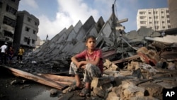 Seorang anak Palestina duduk di antara reruntuhan gedung apartemen di Gaza yang hancur akibat serangan Israel Selasa pagi (26/8).