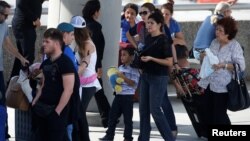 Passengers wait in long lines outside a terminal at Ft. Lauderdale International Airport after it re-opened in Ft. Lauderdale, Florida, Jan. 7, 2017.