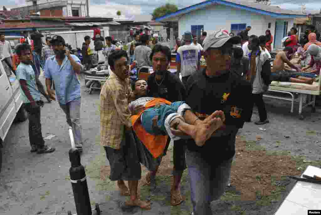 An injured resident is evacuated to the local clinic after a strong earthquake hit in Bener Meriah district in Central Aceh, July 2, 2013. 