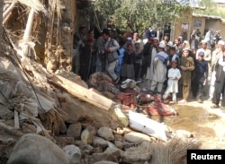 FILE - Students gather at the site of a U.S. drone strike on an Islamic seminary in Hangu district, bordering North Waziristan, Pakistan, Nov. 21, 2013. The strike killed a senior member of the Taliban-linked Haqqani network, Pakistani and Afghan sources said.