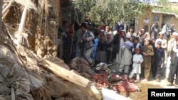 FILE - Students gather at the site of a U.S. drone strike on an Islamic seminary in Hangu district, bordering North Waziristan, Pakistan, Nov. 21, 2013. The strike killed a senior member of the Taliban-linked Haqqani network.
