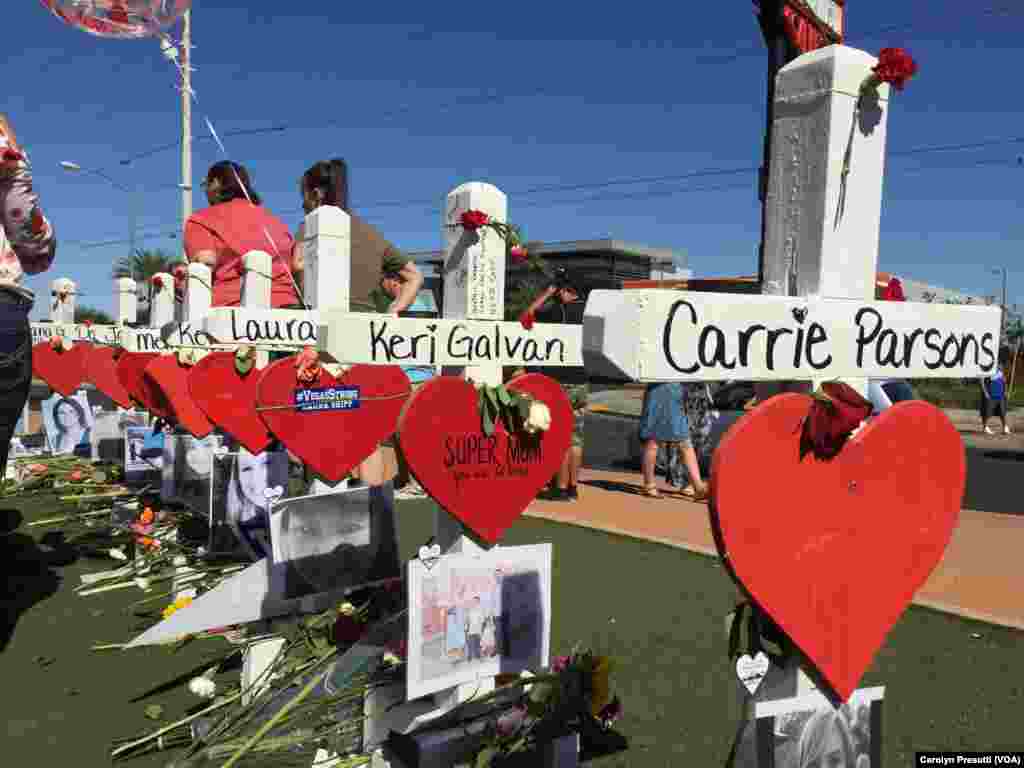 美国拉斯维加斯，悼念2017年10月1日枪击惨案死难者的十字架、照片和鲜花，十字架上有每个遇难者的名字。