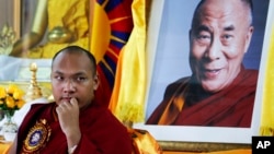 FILE - Tibetan spiritual leader Ogyen Trinley Dorje, the 17th Karmapa, looks on as he sits in front of a portrait of the Dalai Lama during a function commemorating the 50th anniversary of the Tibetan Institute of Medicine and Astrology in Dharmsala, India, June 2, 2011. 
