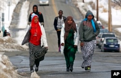 FILE - Students walk home from school in Lewiston, Maine, Jan. 26, 2016. Since February 2000, more than 5,000 Africans have come to Lewiston, a city of 36,500.