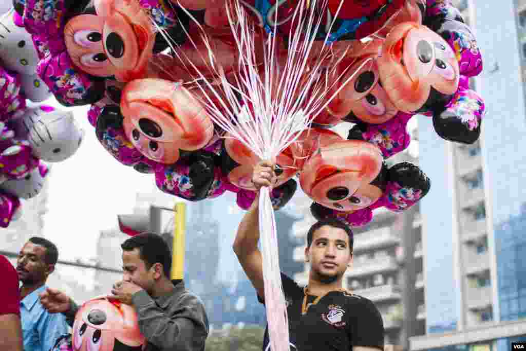 Nader, 28, seorang penjual balon kaki lima, mengatakan, &quot;Saya sudah berjualan balon selama 10 tahun, dan Idul Fitri saat yang paling menguntungkan,&quot; di lapangan Mostafa Mahmoud di Kairo, Mesir, 25 Juni 2017. (H. Elrasam/VOA)