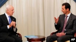 FILE - This SANA photo shows Syrian President Bashar al-Assad, right, speaking with U.N. envoy Staffan de Mistura in Damascus, Nov. 10, 2014.