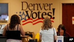 Voters check in with election judges before being allowed to cast primary election ballots at the Denver Elections Division headquarters in Denver, June 26, 2018.
