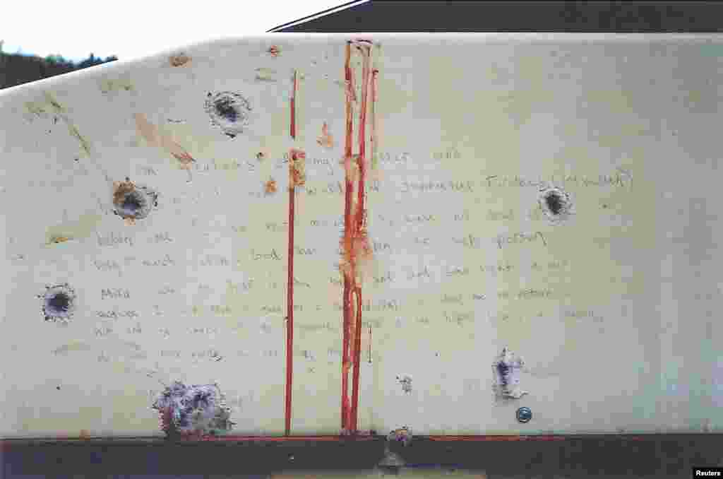 A blood-stained message that prosecutors say Boston Marathon bombing suspect Dzhokhar Tsarnaev wrote on the inside of a boat is seen with bullet holes in an undated evidence picture shown to jurors in Boston, March 10, 2015. 